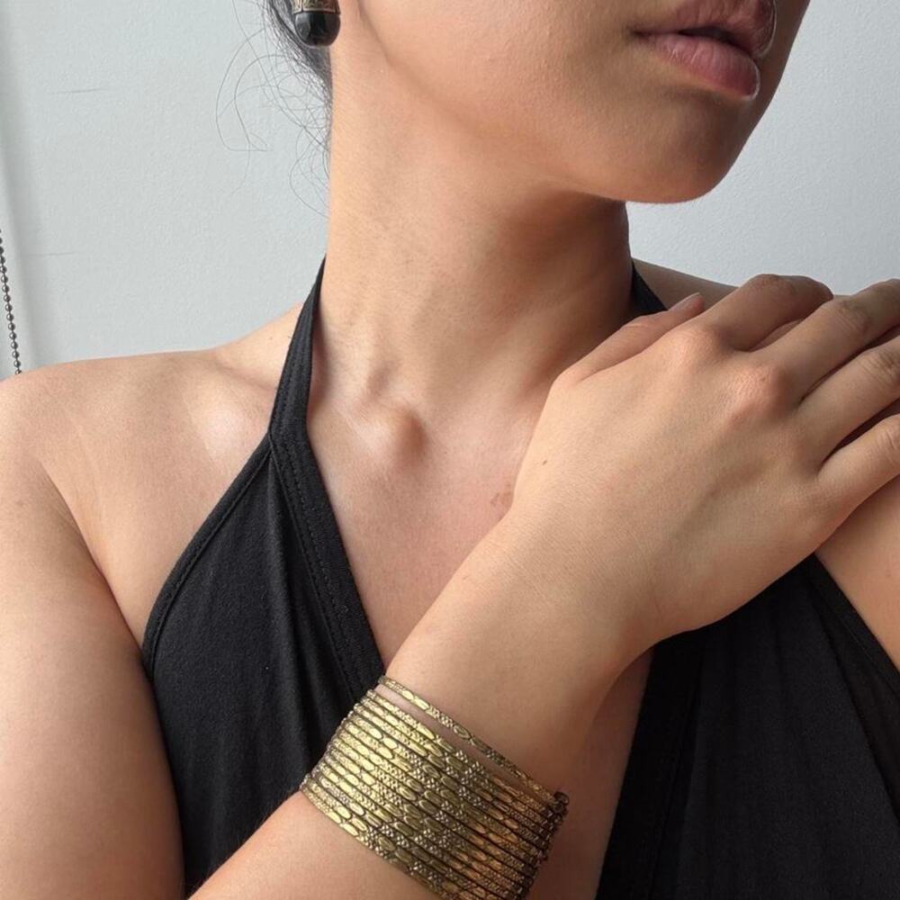 Gold cuff bracelet with horizontal ridges and black onyx drop earrings set